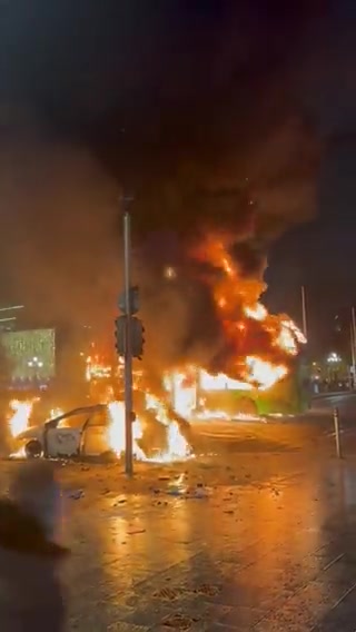 A City Bus and several Police Cars alongside a few Personal Vehicles have been Caught on Fire and Destroyed in Dublin, Ireland tonight during the Riots across the City caused by the Stabbing Attack today